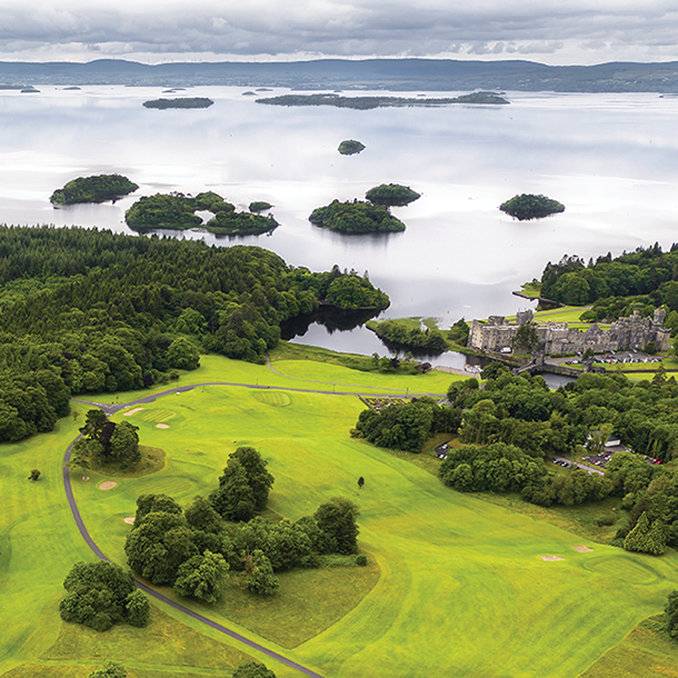 Ashford Castle surrounded by beautiful green forests and landscaping overlooking shores of Lough Corrib